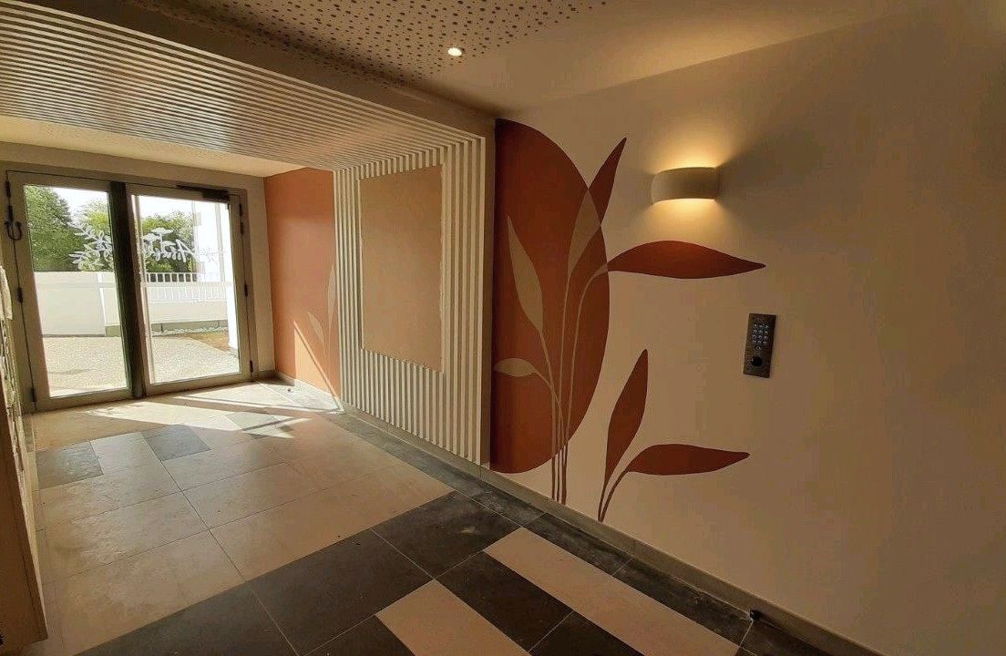 Anderea à Bayonne : hall d’entrée, motif végétal peint et baie vitrée ouvrant sur l’extérieur.