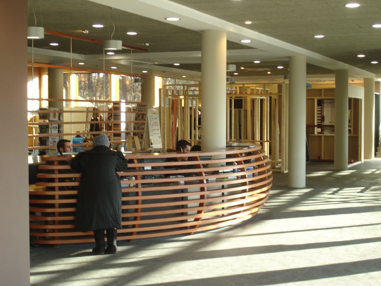 Établissements Bouney à Anglet : showroom, banque d’accueil courbe en lames de bois.