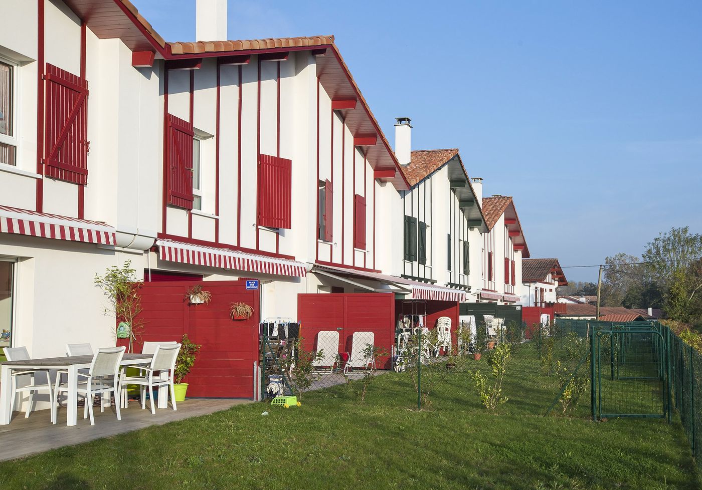 Ibarola à Saint-Pée-sur-Nivelle : maisons en bande à pans de bois rouges, terrasses et jardins.