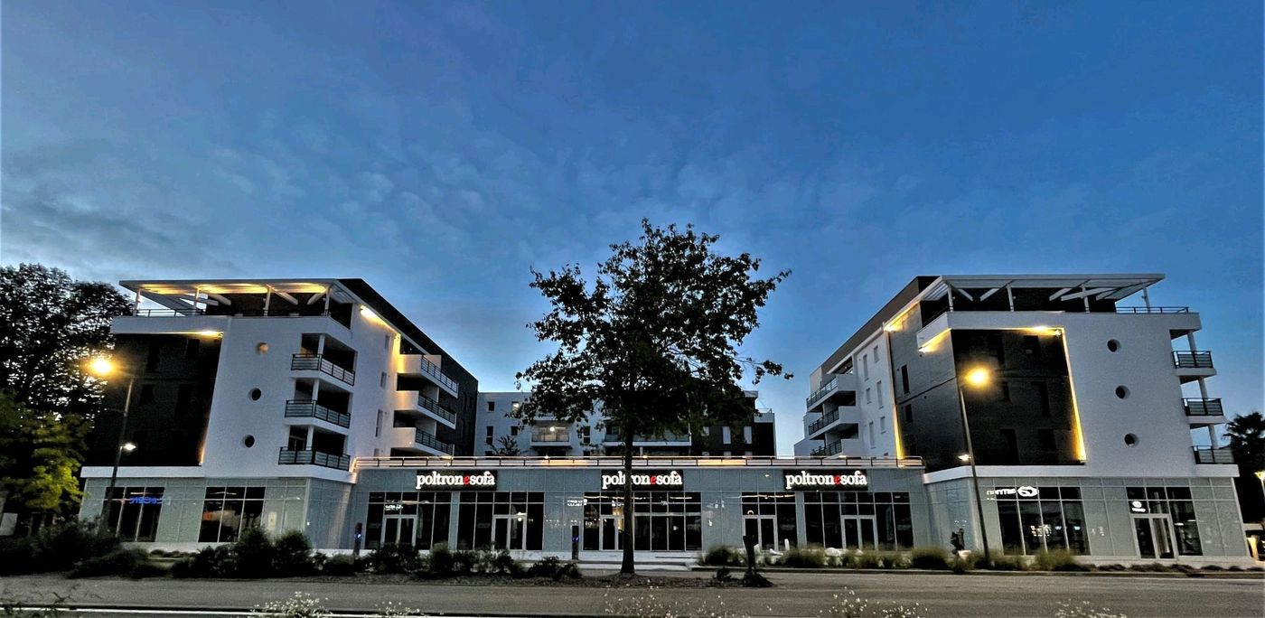 Kalypso à Anglet : vue de nuit des deux bâtiments et du socle commercial éclairé.