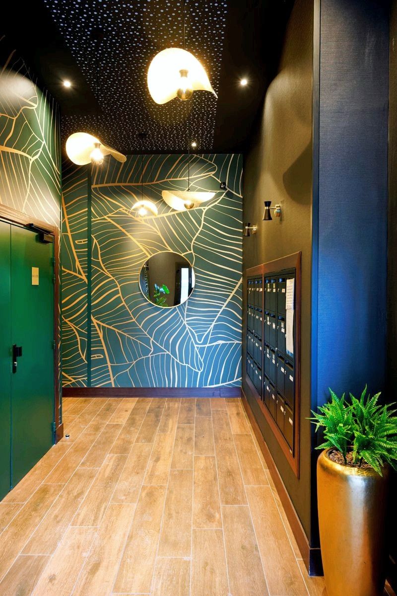 Kalypso à Anglet : hall d’entrée, papier peint à motif de feuilles et suspensions.