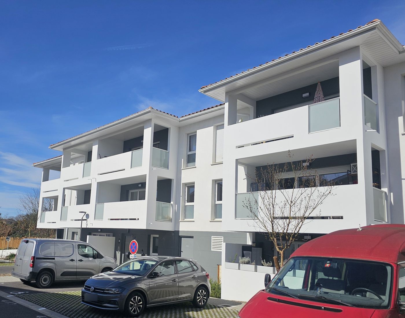 Zura à Bayonne : bâtiment collectif aux balcons blancs et garde-corps opalescents.